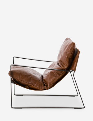 Side view of brown leather Marlyne sling-back accent chair with black metal frame