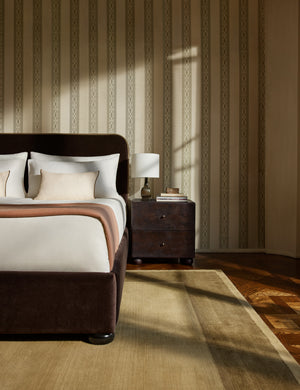 A bedroom featuring the Deller Hand-Loomed Wool Rug by Jake Arnold