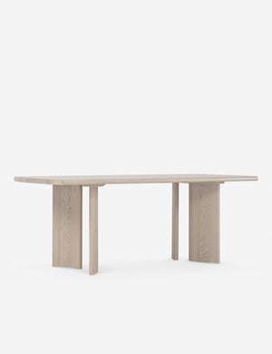 Angled view of the Sun at six crest white oak dining table with curved legs