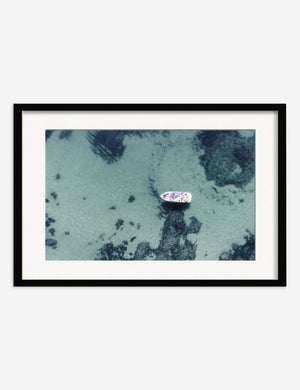 Aerial Ocean Bliss Photography Print in a black frame featuring an aerial view of a boat on shallow waters by Ingrid Beddoes