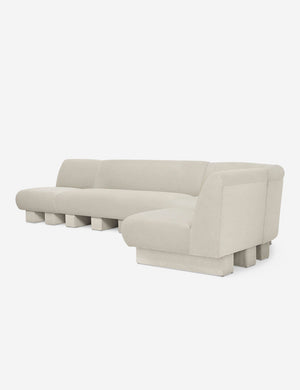 Angled view of the Lena right-facing white boucle sectional sofa with upholstered beam legs.