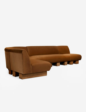 Angled view of the Lena left-facing cognac velvet sectional sofa with upholstered beam legs.