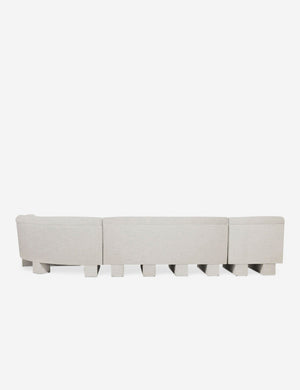 Rear view of the entire Lena right-facing natural linent sectional sofa with upholstered beam legs.