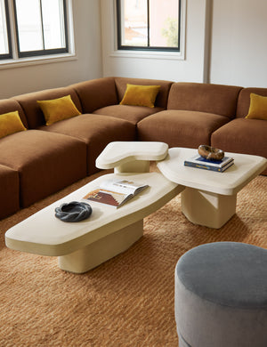 Cyprus striped, tasseled, Moroccan-styled wool rug styled with a modern corner sectional sofa and sculptural nesting coffee table.