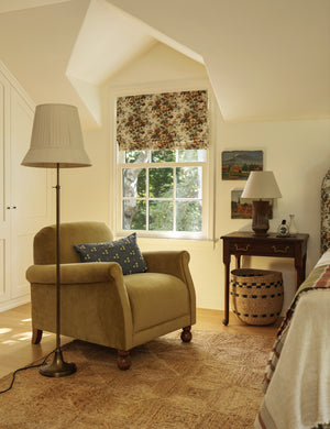 Lily slim metal stem adjustable height floor lamp by Heidi Caillier styled next to an accent chair