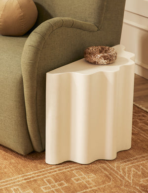 Lune half-moon, scalloped concrete side table styled next to a chair