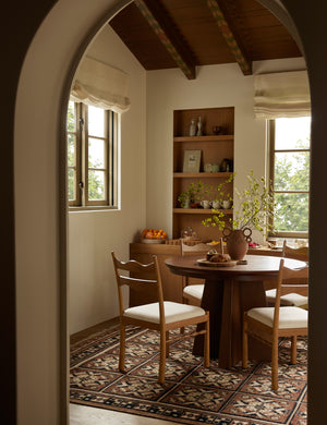 A dining nook featuring the Ovidi heritage motif hand-knotted wool rug.