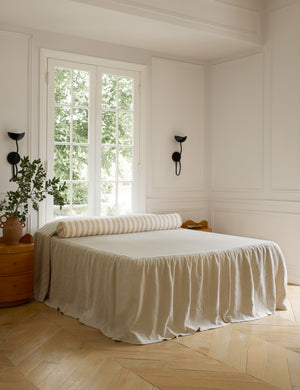 Painterly stripe linen long bolster throw pillow in natural and ivory styled on a bed