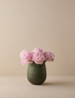 Campden matte green ceramic vase by Heidi Caillier filled with pink flowers.