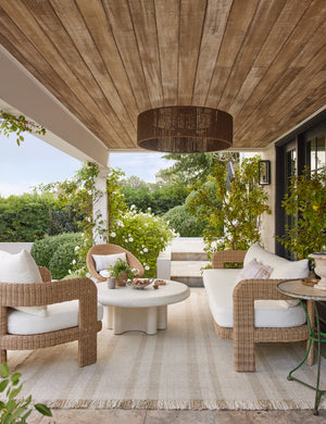 Wicker outdoor lounge furniture sitting on top of the Croze handwoven striped fringed outdoor rug.