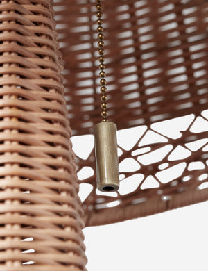 Close up of the pull cord of the Quinley dome rattan coast table lamp.