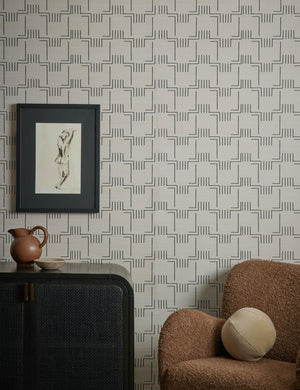 Mesa Grasscloth Wallpaper by Élan Byrd on a wall behind and accent chair and sideboard cabinet.