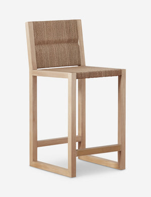 Angled view of the Maritza armless light wood and woven seagrass coastal style counter stool.
