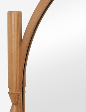 Close up of the top of the Topia arched carved wood frame floor mirror by Ginny Macdonald in natural.
