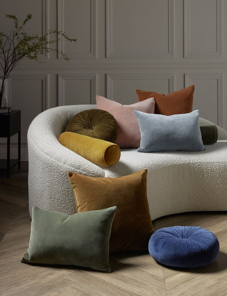 #color::rosewater #style::square  #fill type::with-feather-down-insert  #fill type::pillow-cover-only |   Charlotte velvet pillow in moss, rosewater, ice blue, burnt orange, and toast sit next to and on a cream boucle lounger