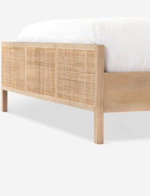 Close-up angled view of the light wood base and cane detailing on the Hannah bed.