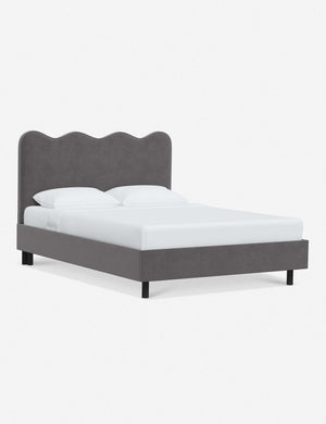 Angled view of Clementine steel velvet platform bed with undulating lined headboard