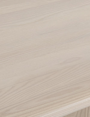 Detailed view of the white oak wood on the Sun at six crest white oak dining table with curved legs