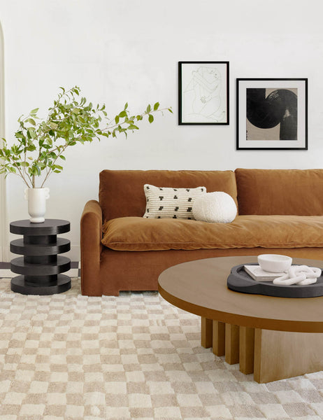 #color::Cognac-Velvet  | The Rupert cognac velvet sofa sits atop a natural and white checkerboard rug behind a round wooden coffee table