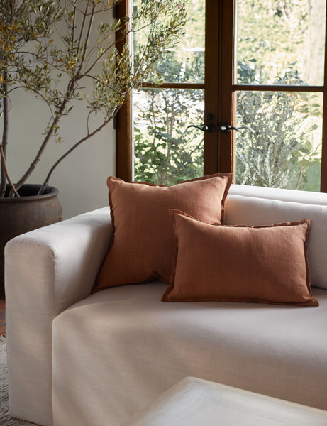 #color::burnt-orange #size::lumbar #fill type::with-feather-down-insert #fill type::pillow-cover-only | The arlo Burnt Orange flax linen pillow in its lumber and square sizes sit together on a natural linen sofa