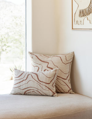 Canyon Terracotta Lumbar and Square Pillows sit on a cushioned white bench