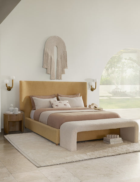 #color::natural-brass #size::left-facing | Natural-brass left-facing Happy Sconce by Regina Andrew is hung on both sides of a golden linen framed bed with a white wall hanging in between